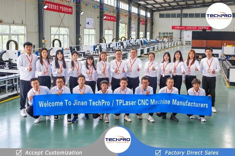 TechPro department employees holding a company banner inside our laser machine workshop